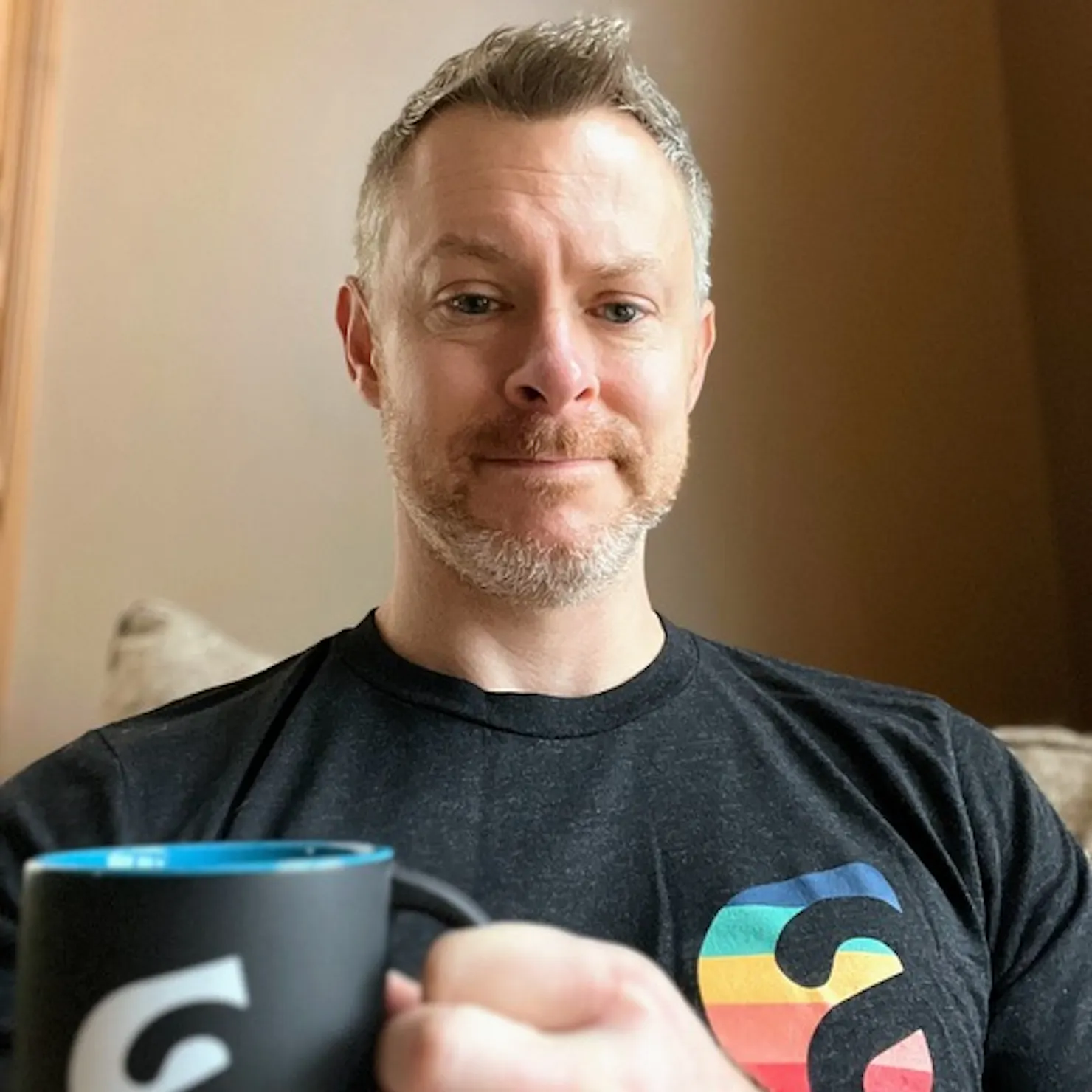 Portrait of Brett Westerman holding a coffee mug and wearing an Ample t-shirt