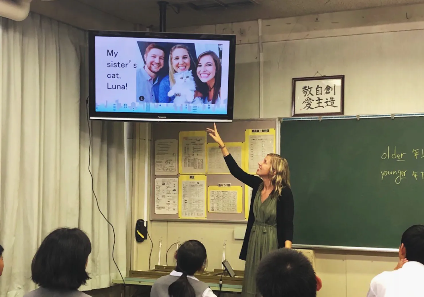 Teacher in a Japanese classroom pointing to a screen showing a slide of her sister's cat, Luna, as students look on