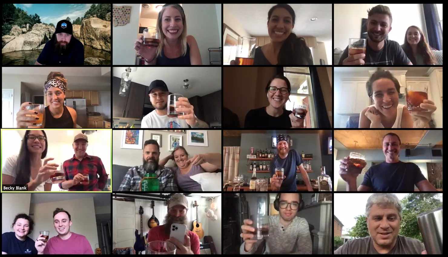 Zoom grid of Ample team members and their spouses raising cocktails during a virtual bartending class