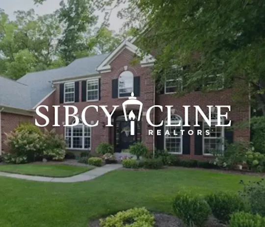Sibcy Cline Realtors logo over a brick two-story home with a landscaped front yard