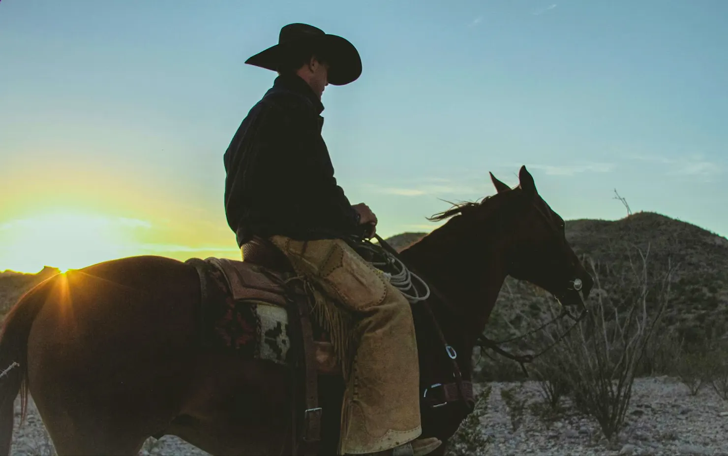 Cowboy on horseback silhouetted against a desert sunset, a nod to Silas's favorite game, Red Dead Redemption